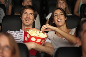 Pärchen im Kino mit Popcorn in der Hand